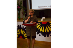 Zdjęcie przedstawia Panią Agnieszkę Pietrykę mówiącą do uczestników konferencji przez mikrofon
